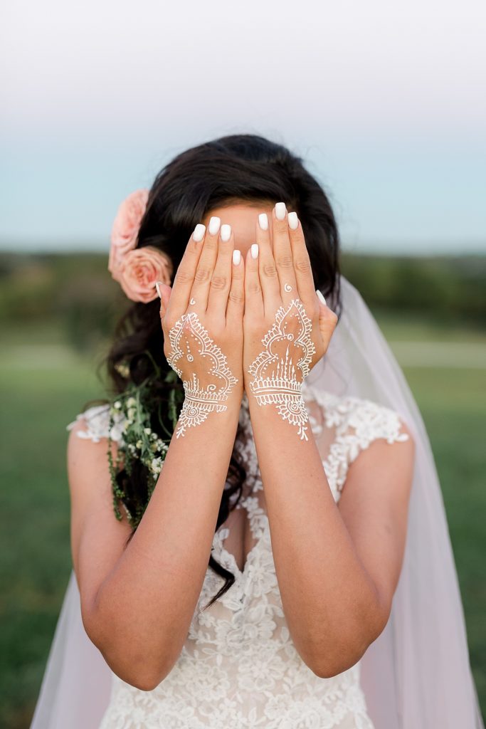 Bride holding her henna hands in front of her face before her wedding ceremony at Weston Timber Barn Farm.