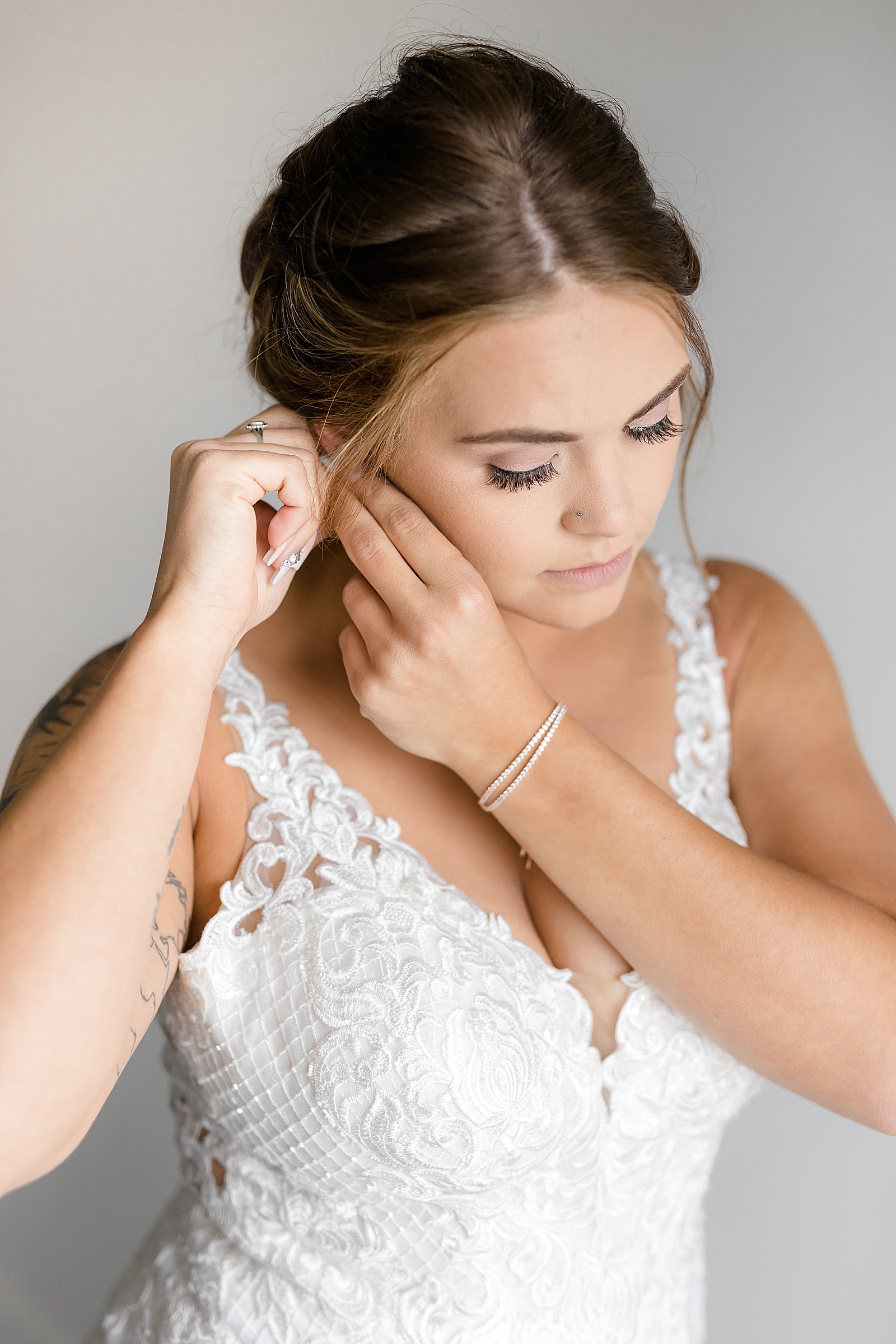 Bride adjusting her earring by North Dakota wedding photographer, Fernweh & Liebe