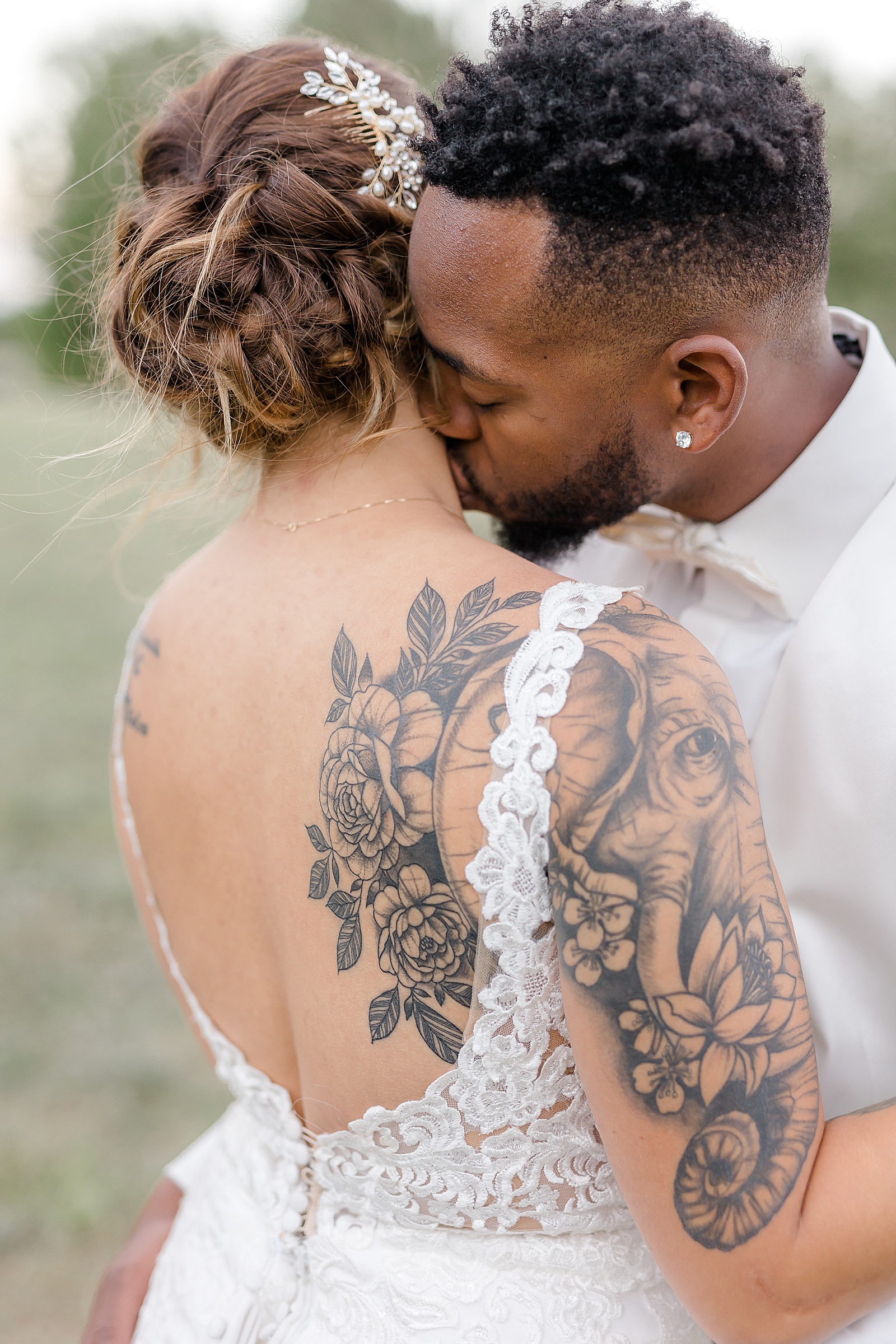 Groom kissing tattooed bride's neck for golden hour portraits 