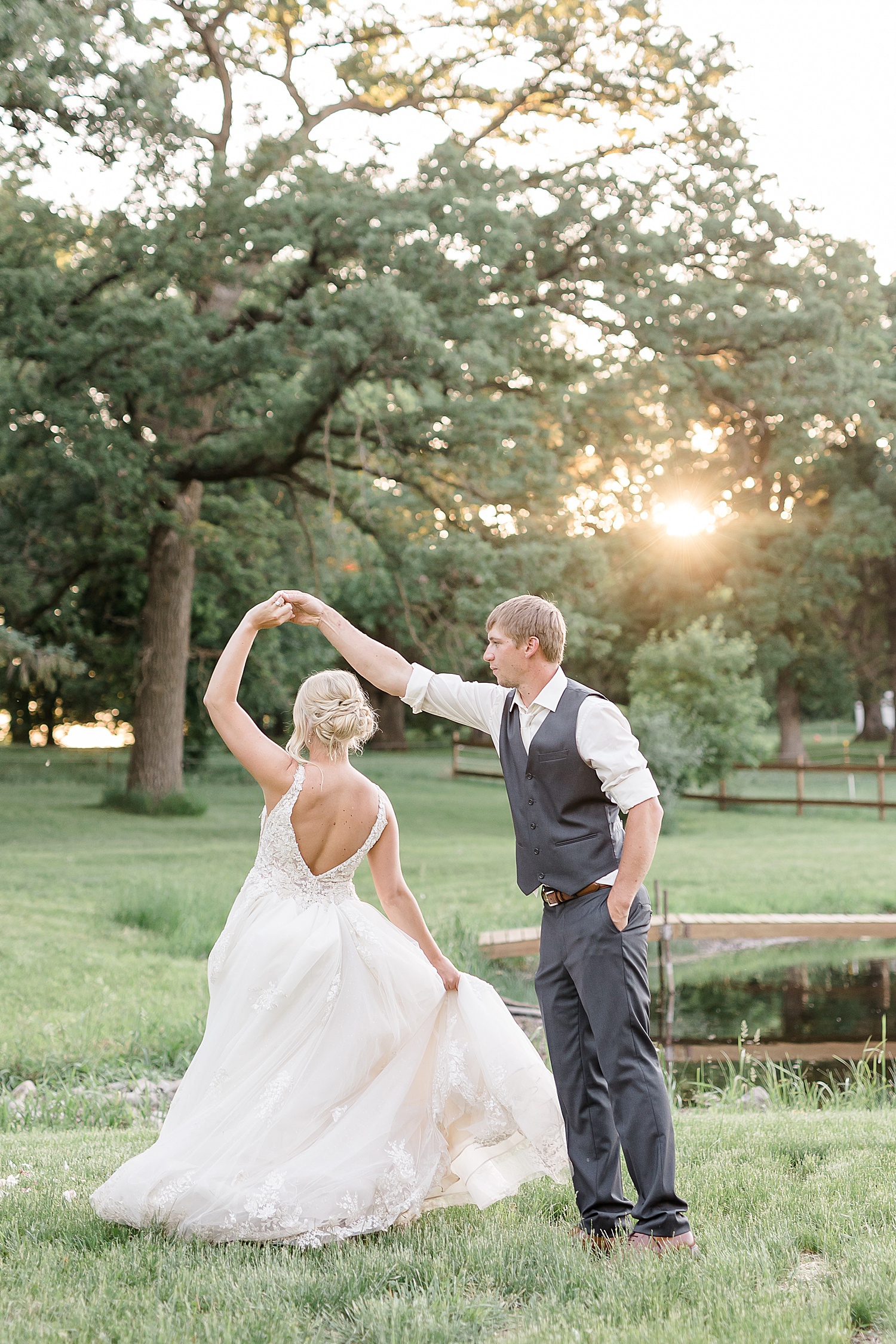 Groom spinning bride in golden hour in a field in Minnesota 