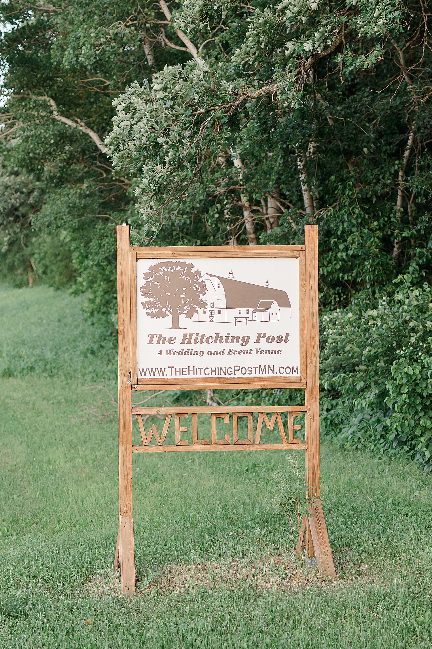 Sign for a Hitching Post Minnesota Wedding in a field 