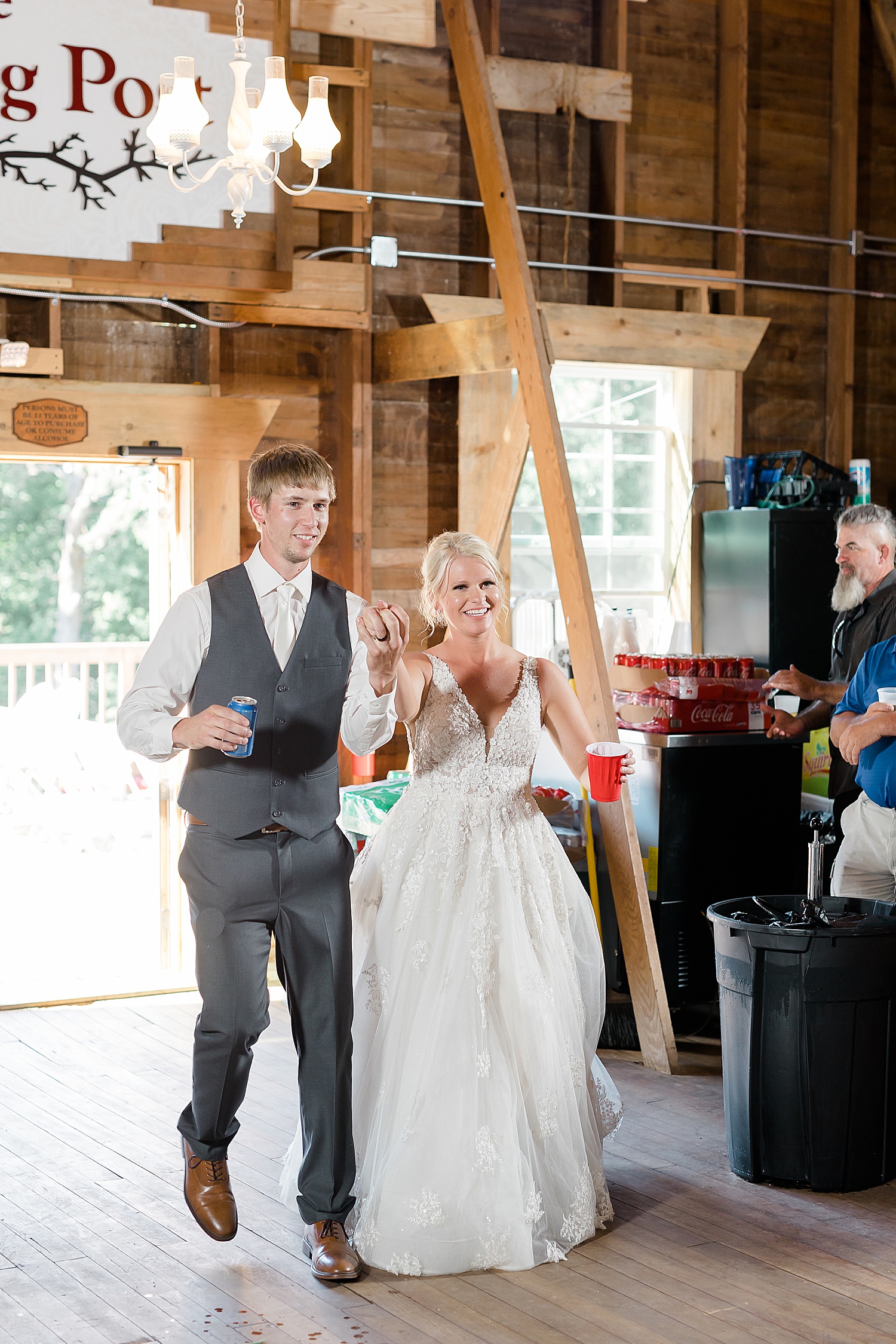 Newlyweds enter their reception with beers in hand by Fernweh and Liebe photographers