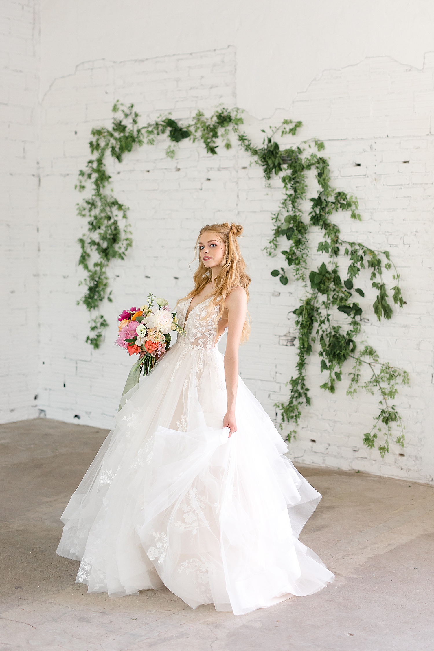 light and airy romantic bride in front of a white brick wall