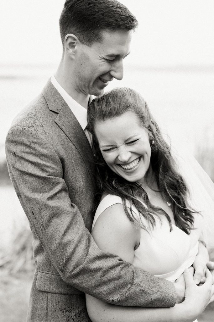 Groom hugging bride while she laughs by Midwest photographer