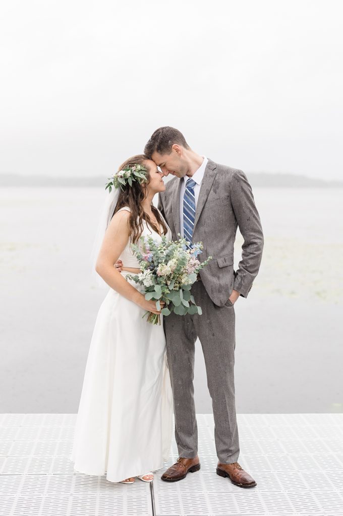 Bride in two piece dress snuggling with groom at their Minnesota Lakeside Wedding