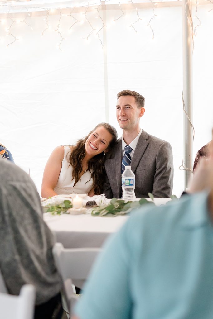 Newlyweds embracing at reception table by Midwest photographer 