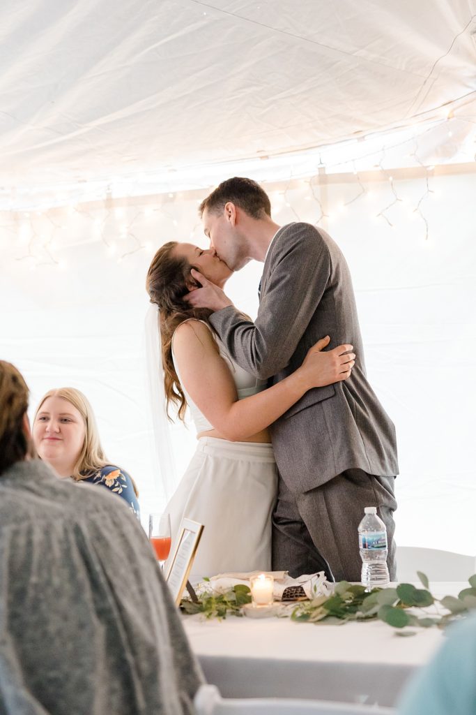 Newlyweds share a kiss at their reception at Minnesota Lakeside Wedding